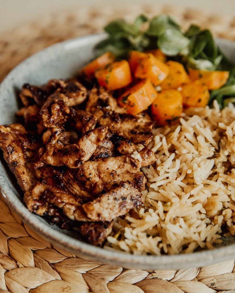 Schale mit gebratenem Hähnchen, Reis, Karotten und Feldsalat
