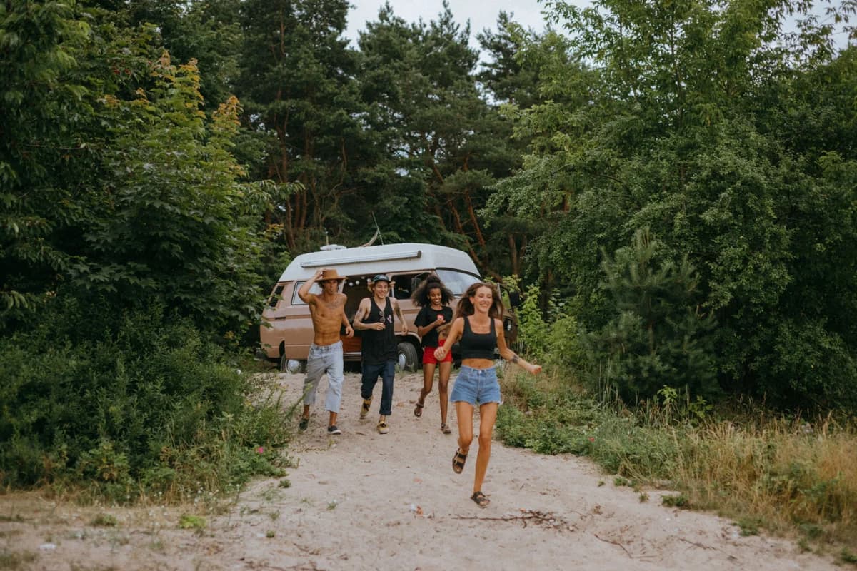 Freunde kommen lachend aus dem Wald auf den Weg